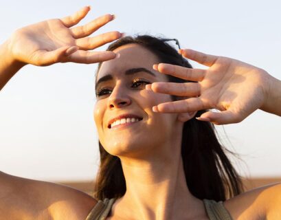 woman covering her face from sun while outdoors