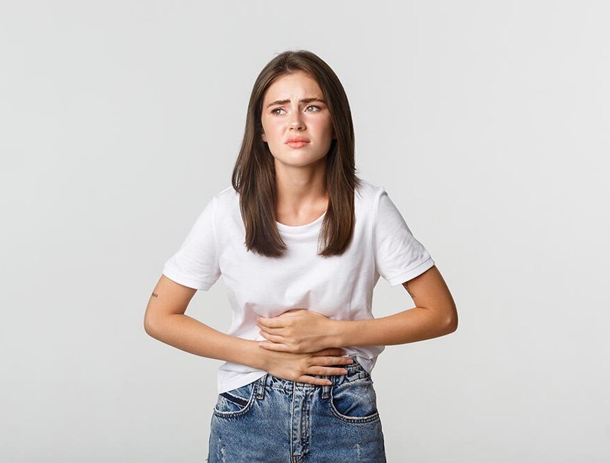 woman having stomach ache bending with hands belly discomfort from menstrual cramps